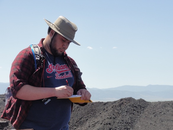 Kyle Burden ('14), shown here taking careful notes, will be working on the welded bomb wall using an approach similar to the one Team Iceland used on pillow lavas. He'll be collecting high-resolution images with a GigaPan and making careful measurements of bombs across the exposure.