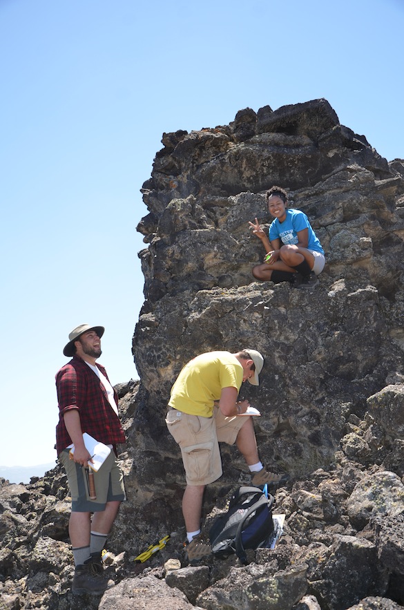 Kyle, Ben, and Candy document the stratigraphy of an isolated lava pillar in the middle of a depression. Credit: T. Wilch