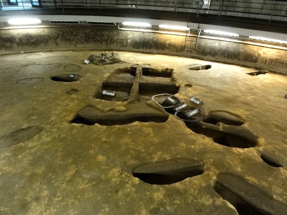 The relics preservation dome displays pit dwellings and pebble clusters in their original excavated state.